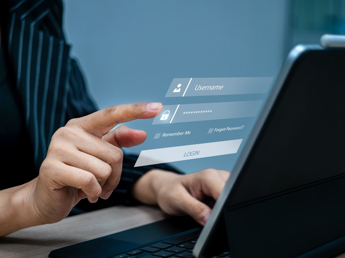 Close-up of hand entering password on virtual login screen on laptop